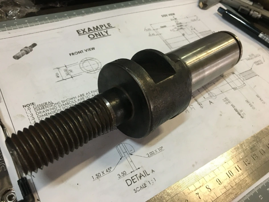 Machined flight shaft alongside its reference drawing.